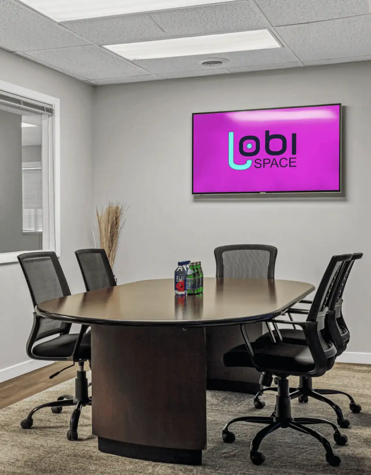 Conference room with oval table and display screen at Lobi Space in Chicago