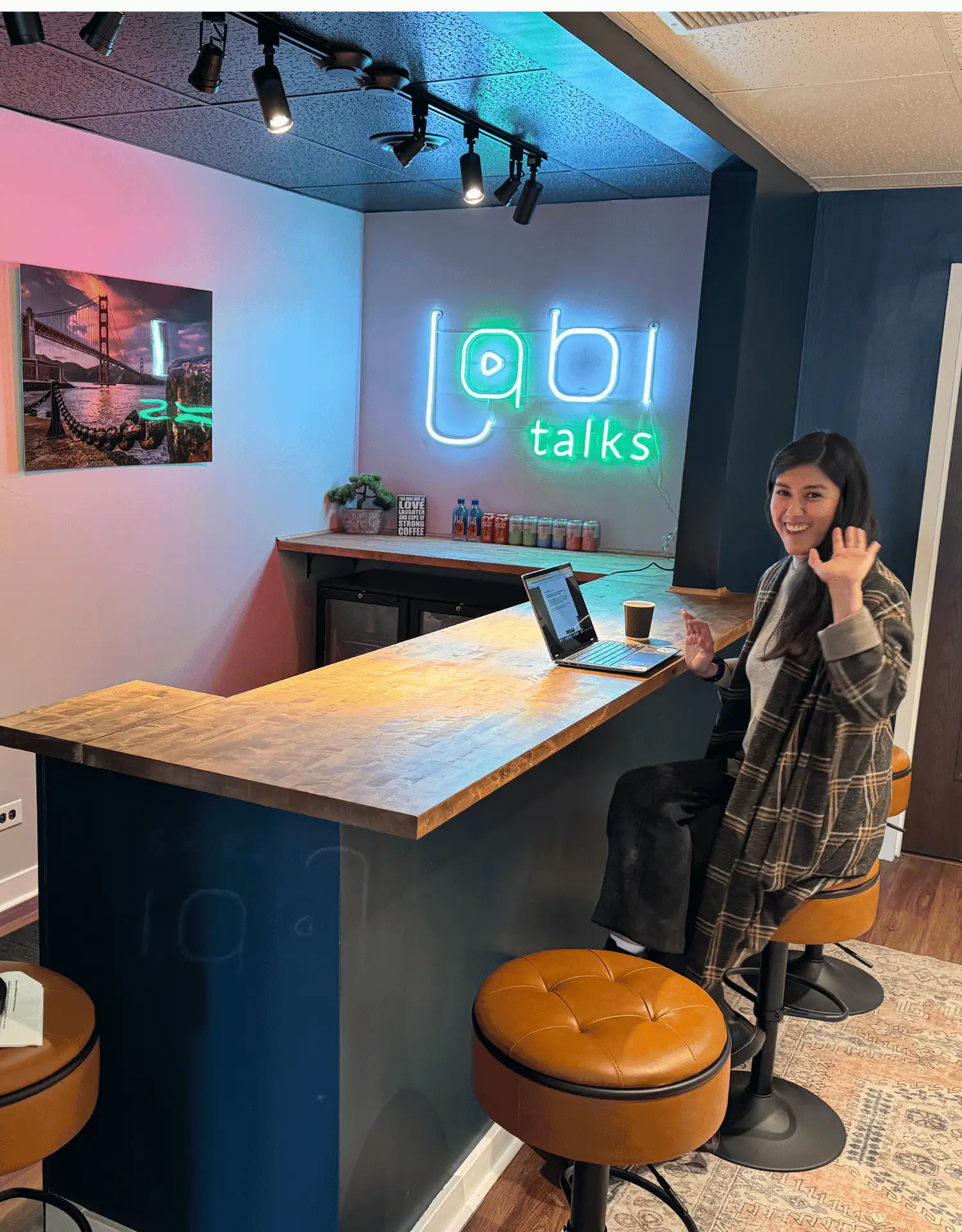 A smiling Lobi Space team member waving at the lobi talks bar in Pilsen, Chicago