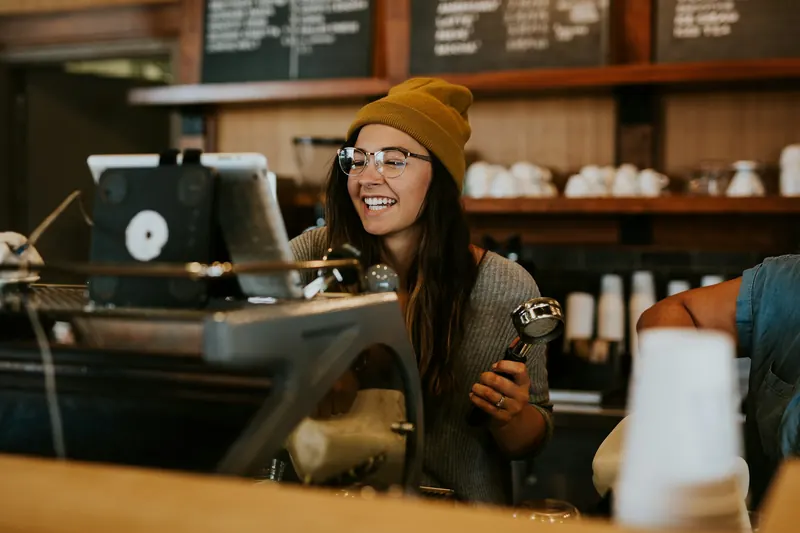 Coffee shop owner holding a portafilter behind the counter