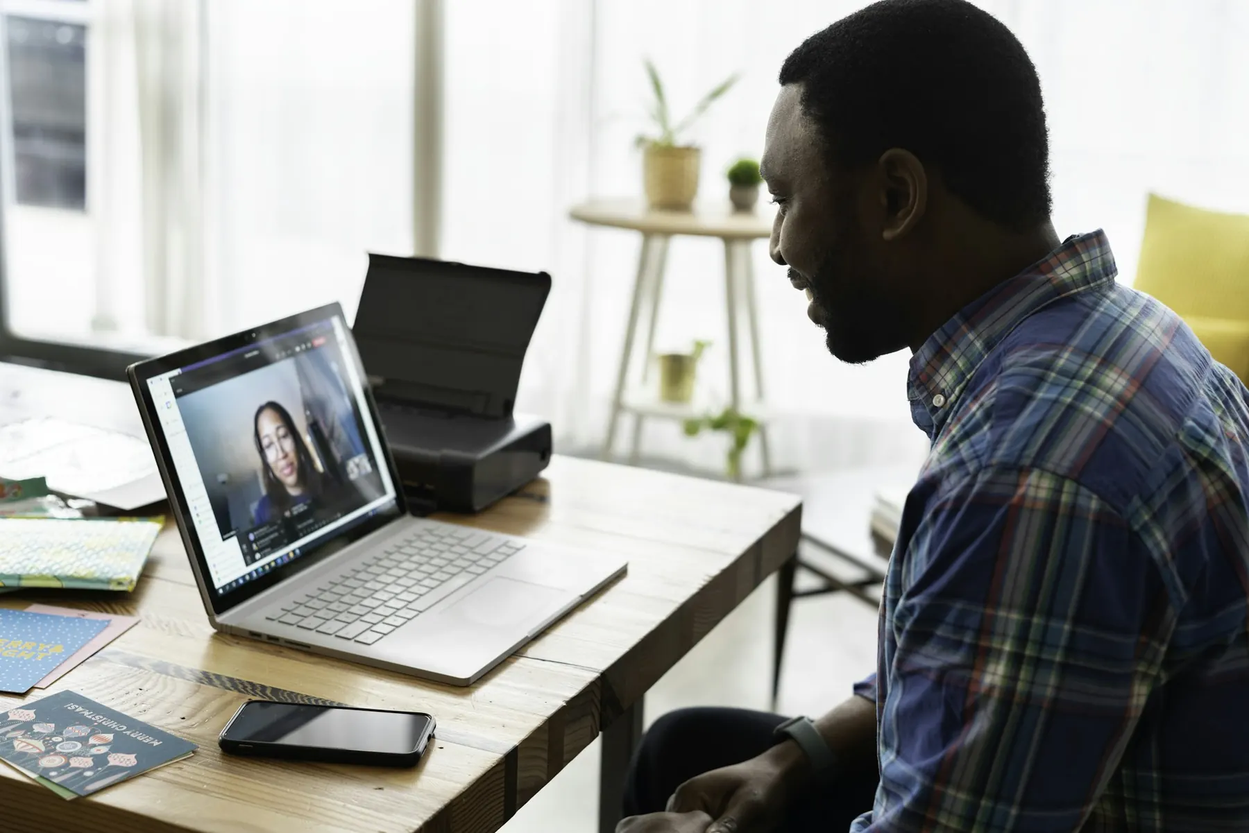 Business owner smiling on a video call at a sunny desk