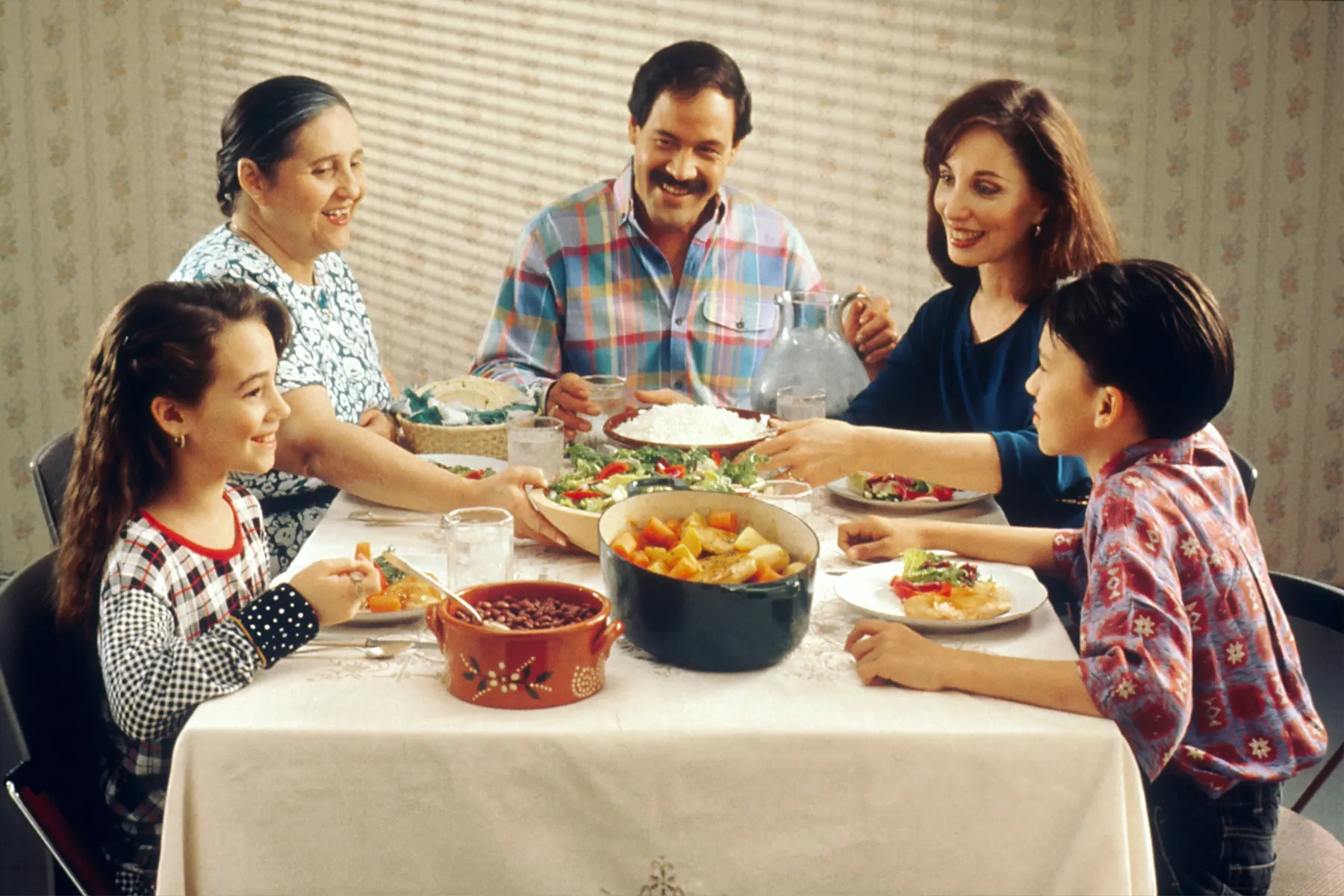 Three generations of a family sharing a home-cooked meal around a kitchen table