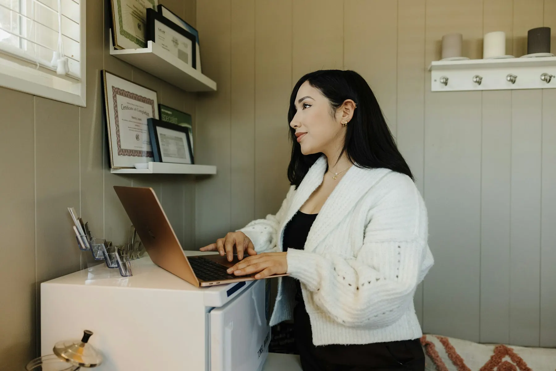 Founder typing on a laptop in her small studio office