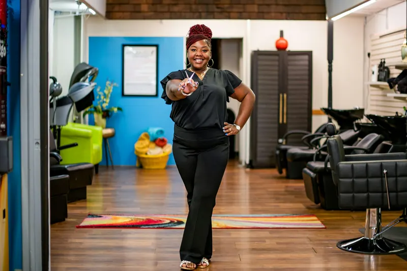 Salon owner holding styling shears in her bright hair salon